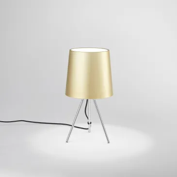 lampada moderna a treppiede proposta in quattro differenti varianti estetiche per un'illuminazione calda e soffusa.